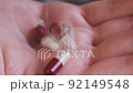 Close-up of translucent capsules with medicine fall into the hand. Macro pills in female hand 92149548