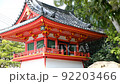 朱色の神社の建物と散る桜の花びら 92203466