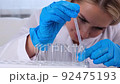 professional scientist laboratory assistant takes and examines samples using a micropipette and test 92475193