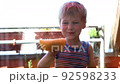 Cute adorable little blond caucasian kid boy enjoy having fun help mom washing balcony door window with soap faom water sponge. Funny male happy child laugh doing chores at home on sunny day 92598233