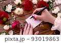 Writing BE HAPPY on a card near flowers close up 93019863