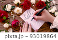 Writing HELLO MY LOVE on a card near flowers close up 93019864
