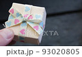 A man's hand holds a gift box with a ribbon. 93020805
