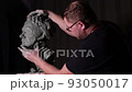 Man sculptor creates sculpt bust clay human woman sculpture. Statue craft creation workshop. 93050017