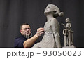 Man sculptor creates sculpt bust clay human woman sculpture. Statue craft creation workshop. 93050023