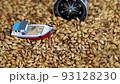 small toy boat falls asleep with grain falling from above 93128230