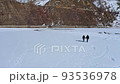 Couple Holding Hands While Walking In The Frozen And Snow-covered Lake At Winter In Sissu, Himachal Pradesh, India. - aerial pullback 93536978
