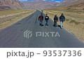 Group Of Friends Walking On Asphalt Road In Sarchu, Himachal Pradesh, India. drone pullback ascend 93537336