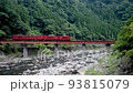 A red train crossing the Kusugawa iron bridge 93815079