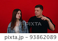Dissatisfied offended young couple, shows neglect and negative emotions on a red background. People lifestyle concept. They look at each other 93862089