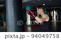 Boxing, man fighter trains his punches, beats a punching bag, training day in the boxing gym. 94049758