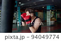 Boxing, man fighter trains his punches, beats a punching bag, training day in the boxing gym. 94049774