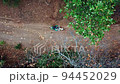 Motorcycle Driving Across Dirt Road On The Forest Mountains In The United States. Topdown Shot 94452029