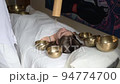 hand using a bamboo Koshi chime during sound healing therapy with tibetan singing bowls over a woman hand using a bamboo Koshi chime during sound healing therapy with tibetan singing bowls over a woman 94774700