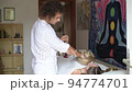 A man wearing in white doing healing sound massage with tibetan singing bowl to a young woman indoor A man wearing in white doing healing sound massage with tibetan singing bowl to a young woman indoor 94774701