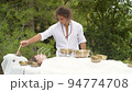 A man wearing in white doing healing sound massage with tibetan singing bowl to a young woman A man wearing in white doing healing sound massage with tibetan singing bowl to a young woman 94774708