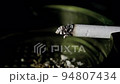 Lit cigarette burning in ashtray close up 94807434