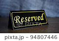 Putting reserved sign on a restaurant table 94807446