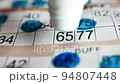Playing bingo, marking numbers with blue marker 94807448
