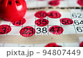 Playing bingo, marking numbers with red marker 94807449