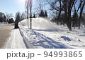 Cleaning technique with snowblower. Janitor cleans winter park with snowplough. 94993865