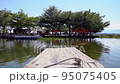 Wooden boat is docking to an island. 95075405