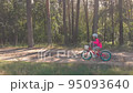 Little girl on bicycle and forest tracking camera movement 95093640