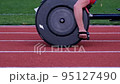 athlete on wheelchair racing riding on stadium track 95127490