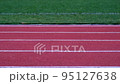 red running track of stadium with green field 95127638