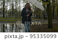 Smiling woman walking near a puddle 95335099