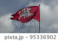 Flag with coat of arms of Lithuania flying with sky at background 95336902