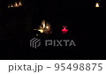 All Saints Day. Candles burn on graves at cemetery at night. All Hallows Eve / Day of All the Saints / Solemnity of All Saints / 1st November / Happy Halloween. Zoom out shot. 4K 95498875