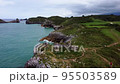 Aerial View of rocky coastline with cliffs and the old ruins of a hermitage 95503589