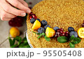 Diet honey cake that does not contain sugar, gluten, decorated with fresh fruits, kumquat, berries and mint leaves 95505408