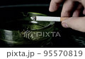 Lit cigarette burning in ashtray close up 95570819