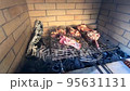 Beef steaks on the bone are grilled on a grate over coals 95631131
