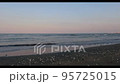 夕暮れ時、海岸に打ち寄せる波 95725015