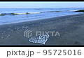 海岸にハートの形に並べられた貝がら、打ち寄せる波 95725016