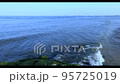 穏やかな海の波と海藻がついた岩 95725019