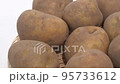 Potatoes on a colander rotating white back 95733612