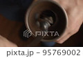 Man using manual coffee grinder 95769002