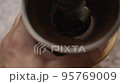Man using manual coffee grinder 95769009