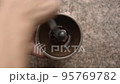 Man using manual coffee grinder 95769782