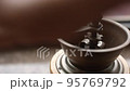 Man using manual coffee grinder 95769792
