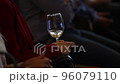 white wine in a glass in the hands of a girl in red. close-up 96079110