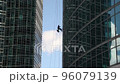 Industrial mountaineering. Window cleaner performs work between two skyscrapers 96079139
