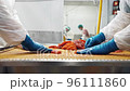 Employees of seafood factory with gloved hands sort red salmon caviar on a net. 96111860