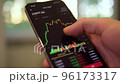Businessman scrolling on his phone chart of cryptocurrency value. 96173317