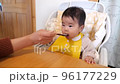Baby eating first baby food with a spoon 96177229
