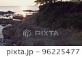海岸の岩場から徐々にあらわれる夕日 96225477
